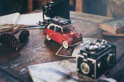 焦点摄影的红色汽车压铸模型松果旁边
